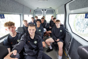 Forest Green Rovers’ Youth Team are sat, facing the camera, inside their new minibus 